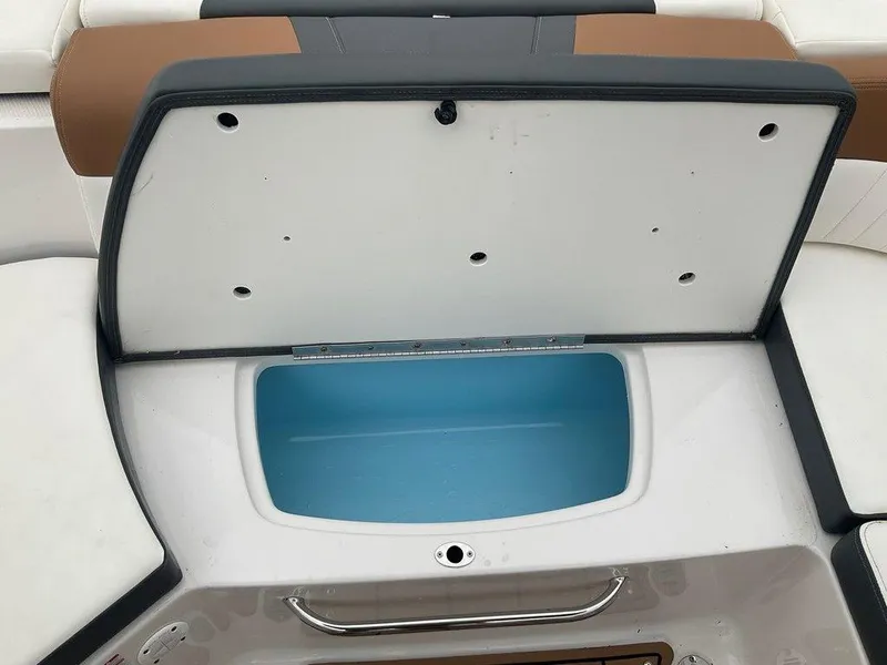 Slide: The Image of Open storage compartment on 2023 Chaparral 23 SSi boat, featuring blue interior. - 32