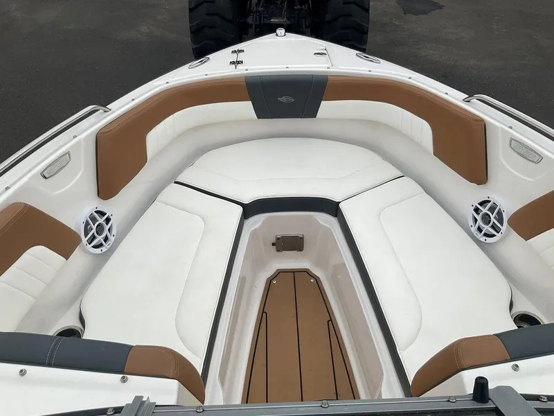 Slide: The Image of 2023 Chaparral 23 SSi boat interior with white and brown seating, featuring speakers and storage. - 36