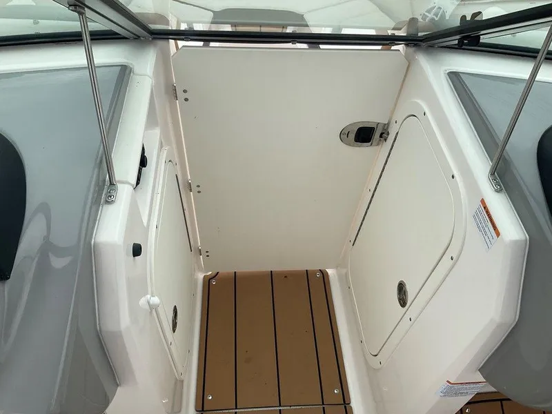 Slide: The Image of 2023 Chaparral 23 SSi boat interior with storage compartments and teak flooring. - 37