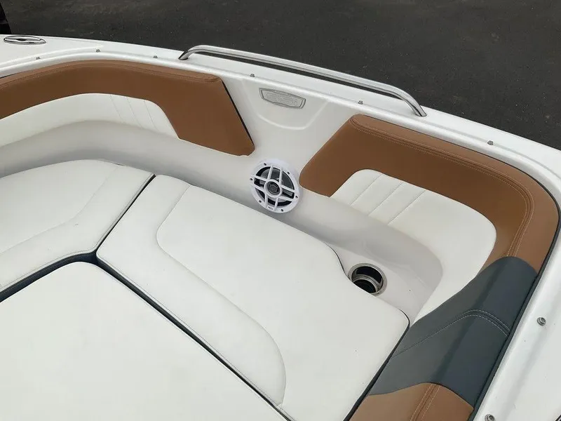 Slide: The Image of 2023 Chaparral 23 SSi boat interior with white and brown seating, speaker, and cup holder. - 38