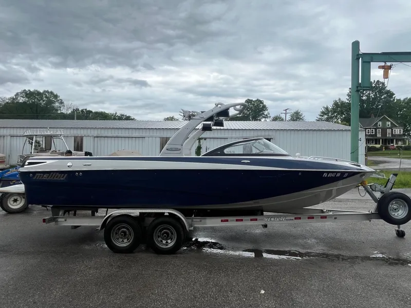 The Image of 2007 Malibu Wakesetter 247 LSV boat on trailer, overcast sky background. - 1