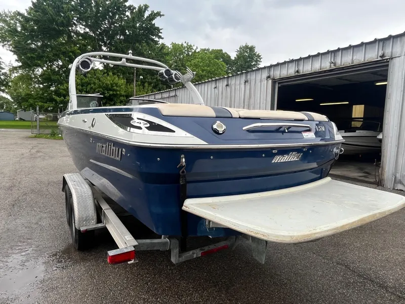 Slide: The Image of 2007 Malibu Wakesetter 247 LSV boat on trailer, parked near a garage. - 5