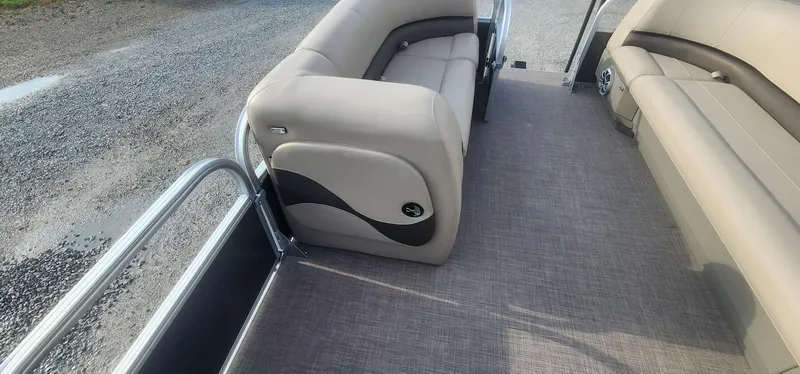 Slide: The Image of 2024 Sun Tracker Party Barge 18 DLX interior with beige seating and gray flooring. - 10