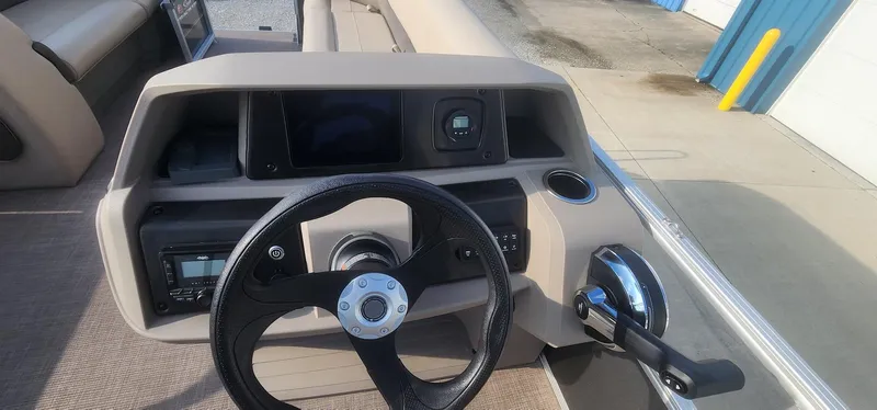 Slide: The Image of 2024 Sun Tracker Party Barge 18 DLX dashboard with steering wheel and control panel. - 11