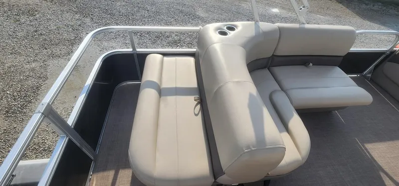 Slide: The Image of 2024 Sun Tracker Party Barge 18 DLX with beige seating and cup holders on deck. - 17