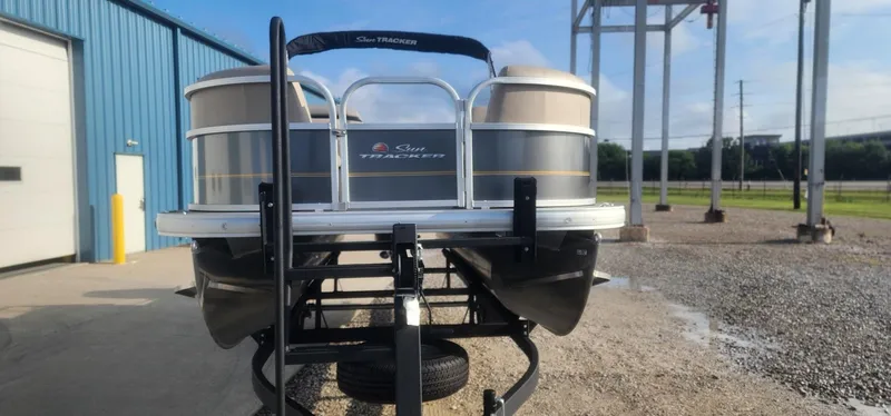 Slide: The Image of 2024 Sun Tracker Party Barge 18 DLX pontoon boat on trailer, parked outdoors. - 3