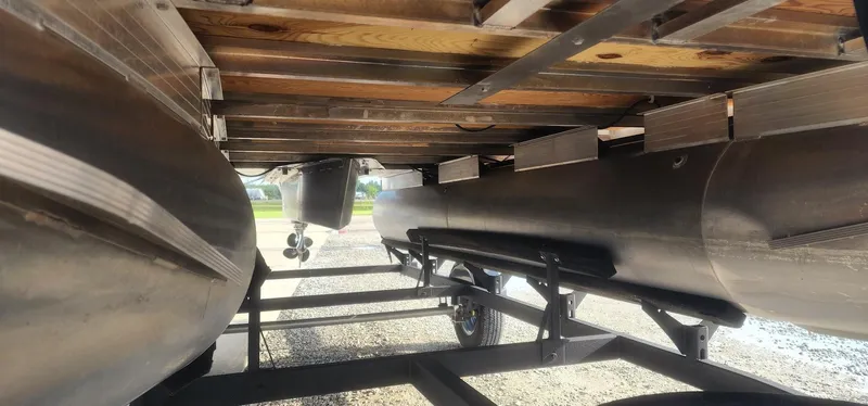 Slide: The Image of Underneath view of 2024 Sun Tracker Party Barge 18 DLX pontoon boat on trailer. - 5