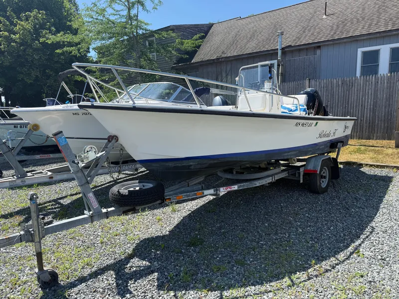 Slide: The Image of 1998 C-Hawk 18 boat on trailer, parked outdoors near a wooden fence. - 10