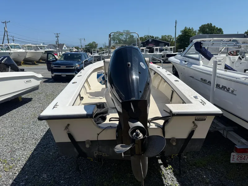 Slide: The Image of 1998 C-Hawk 18 boat with outboard motor in a marina, surrounded by other boats. - 2