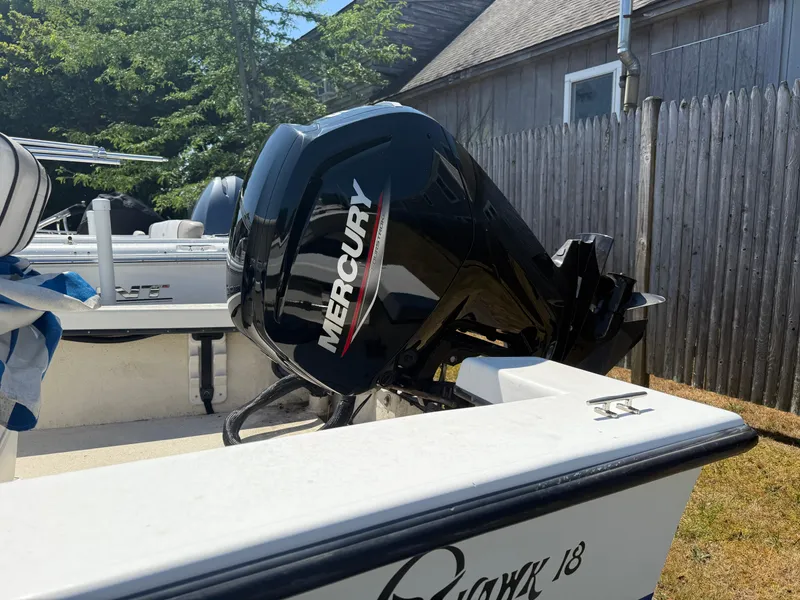 Slide: The Image of 1998 C-Hawk 18 boat with Mercury outboard motor, parked near wooden fence. - 3