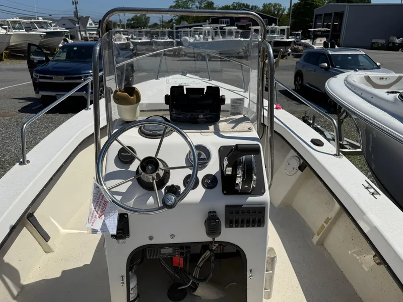 Slide: The Image of 1998 C-Hawk 18 boat dashboard with steering wheel and controls, parked in a marina. - 9