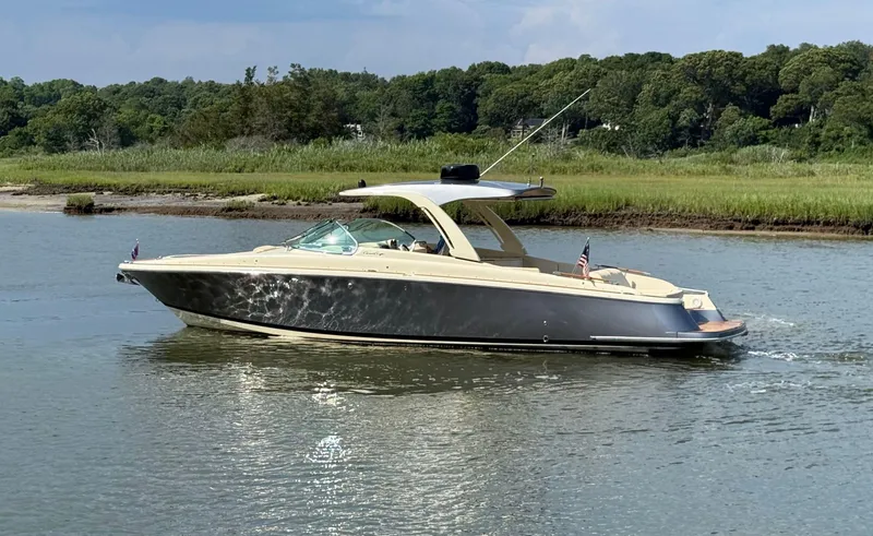 Slide: The Image of 2022 Chris-Craft Launch 35 GT I/O Heritage Edition boat cruising on a calm river. - 2