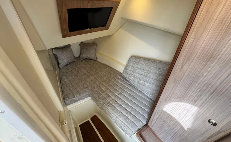 Slide: The Image of 2022 Chris-Craft Launch 35 GT I/O Heritage Edition cabin interior with cozy bedding and TV. - 33
