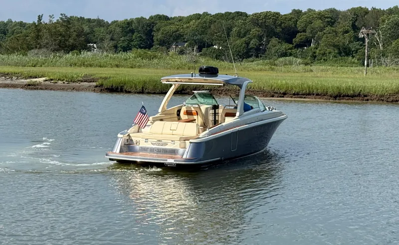 Slide: The Image of 2022 Chris-Craft Launch 35 GT I/O Heritage Edition cruising on a serene waterway. - 4