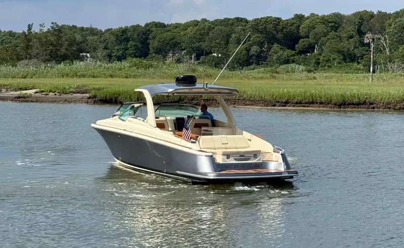 Slide: The Image of 2022 Chris-Craft Launch 35 GT I/O Heritage Edition cruising on a serene river. - 5