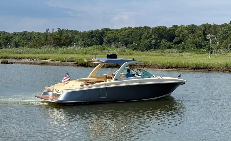 Slide: The Image of 2022 Chris-Craft Launch 35 GT I/O Heritage Edition cruising on a serene river. - 6