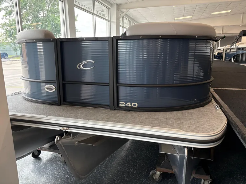 The Image of 2025 Crest 240 SLRC pontoon boat displayed indoors, featuring sleek blue design. - 0
