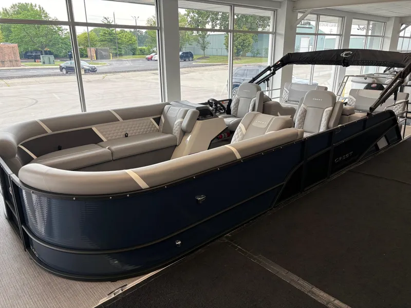 Slide: The Image of 2025 Crest 240 SLRC pontoon boat with luxurious seating in a showroom. - 1