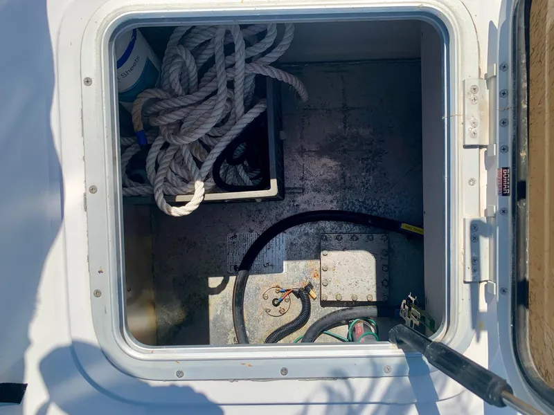 Slide: The Image of Storage compartment on a 2003 PDQ-34 boat with ropes and cleaning supplies. - 14