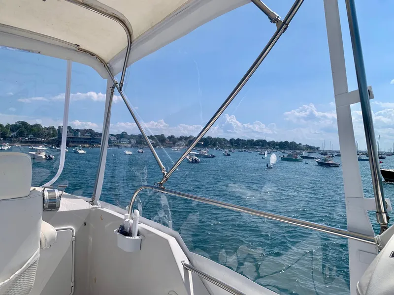 Slide: The Image of Interior of 2003 PDQ-34 boat with blue seating, wooden table, and decorative pillows. - 19