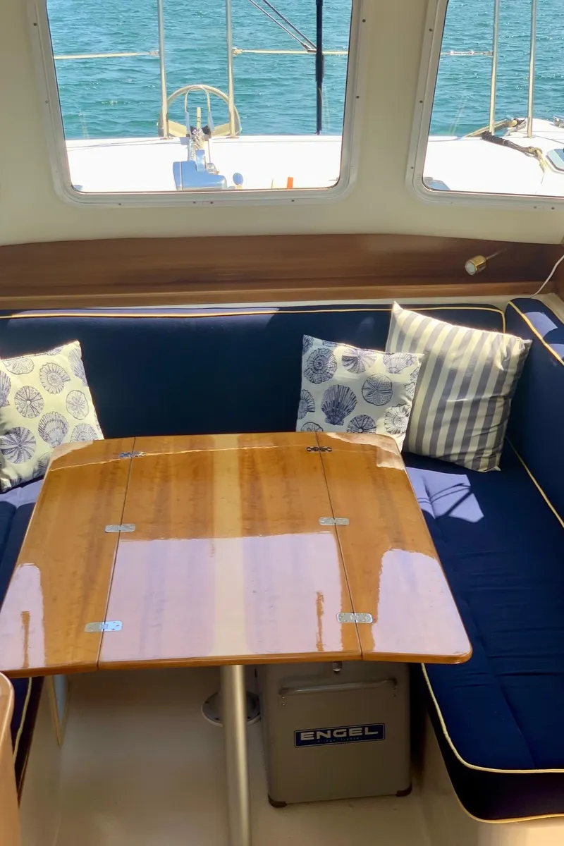 Slide: The Image of Interior of 2003 PDQ-34 boat with wooden finish, blue seating, and ocean view. - 20