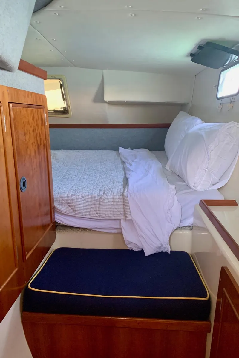 Slide: The Image of Cozy cabin interior of 2003 PDQ-34 boat with wooden steps and bed. - 23