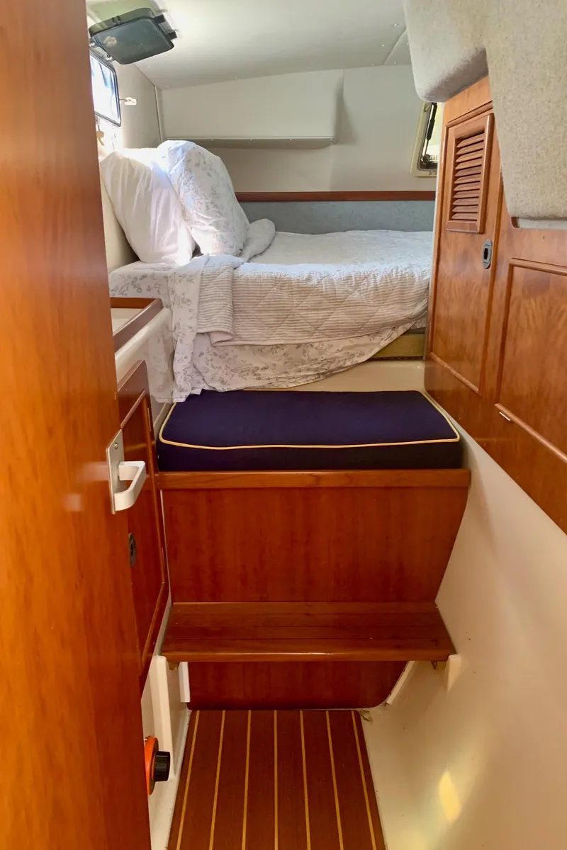 Slide: The Image of Compact bathroom in 2003 PDQ-34 boat, featuring a toilet and wooden accents. - 24