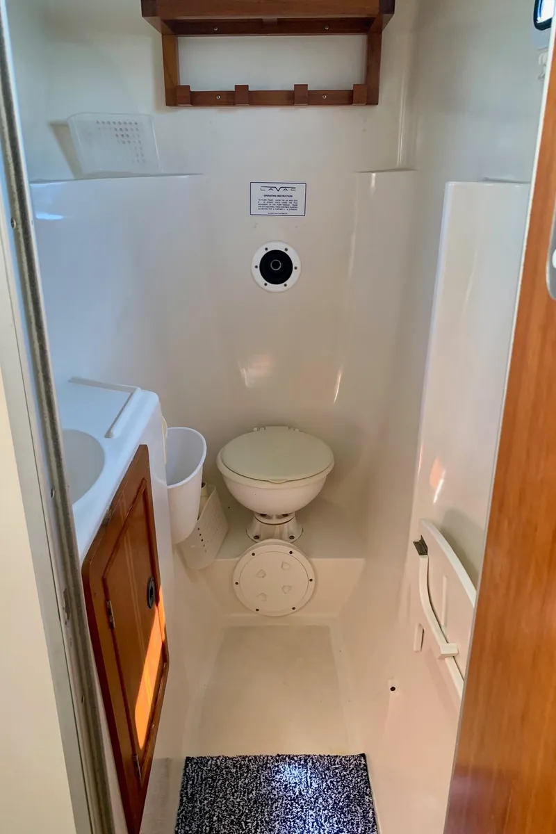 Slide: The Image of Interior of a 2003 PDQ-34 boat showing a storage compartment and basket. - 26