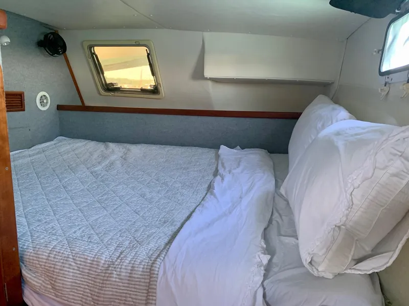 Slide: The Image of Cozy cabin bedroom in 2003 PDQ-34 boat with bed, pillows, and windows. - 5