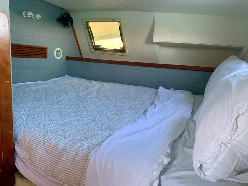 Slide: The Image of Cozy cabin bedroom in 2003 PDQ-34 boat with quilted bedding and porthole windows. - 6