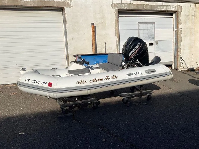 The Image of 2016 Brig F330HT inflatable boat with Mercury engine, parked outside garage. - 1