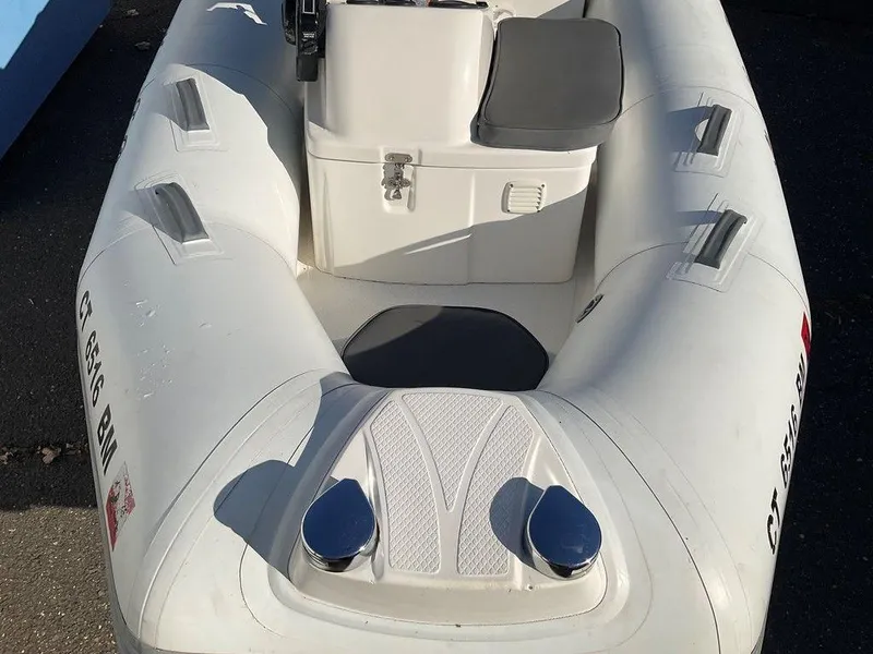 Slide: The Image of 2016 Brig F330HT inflatable boat with seating and storage, docked on pavement. - 6