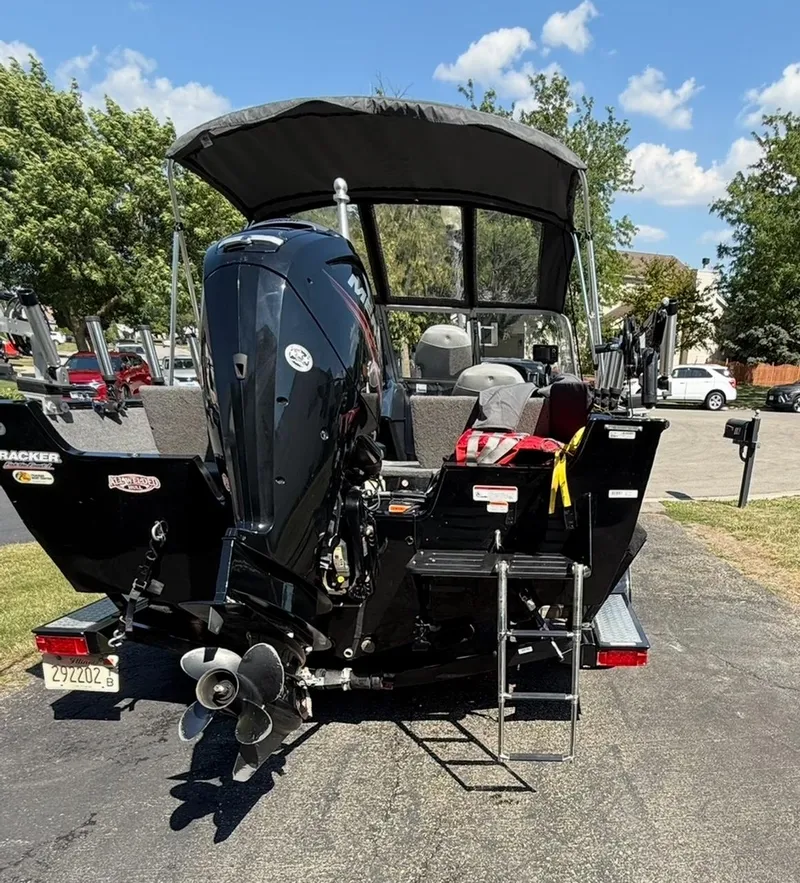 Slide: The Image of 2015 Tracker Pro Guide V-175 WT boat with outboard motor and canopy on a sunny day. - 11