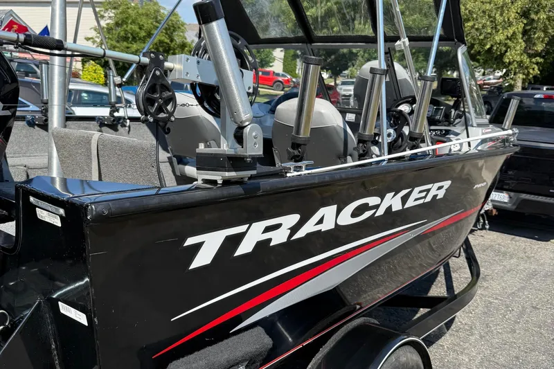 Slide: The Image of 2015 Tracker Pro Guide V-175 WT boat with fishing rod holders, parked outdoors. - 5