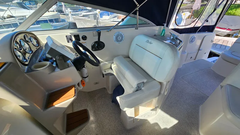 Slide: The Image of 2003 Rinker Fiesta Vee 270 boat interior with helm, steering wheel, and seating. - 10