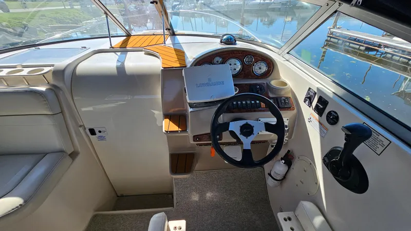 Slide: The Image of 2003 Rinker Fiesta Vee 270 boat cockpit with steering wheel and control panel. - 11