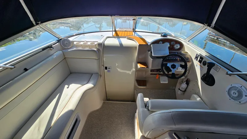 Slide: The Image of 2003 Rinker Fiesta Vee 270 boat interior with steering wheel and seating area. - 12