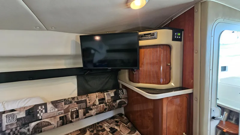 Slide: The Image of Interior of 2003 Rinker Fiesta Vee 270 with TV and patterned seating. - 16