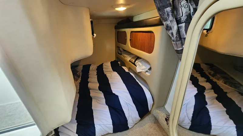 Slide: The Image of 2003 Rinker Fiesta Vee 270 cabin interior with cozy bed and striped bedding. - 17