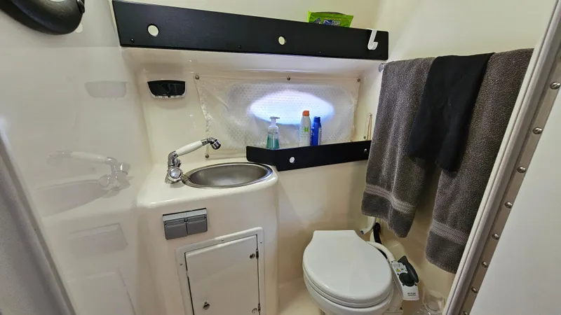 Slide: The Image of 2003 Rinker Fiesta Vee 270 bathroom with sink, toilet, and towels. - 19