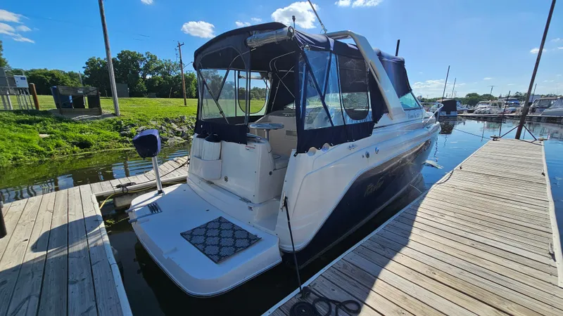 Slide: The Image of 2003 Rinker Fiesta Vee 270 boat docked at marina under clear blue sky. - 2