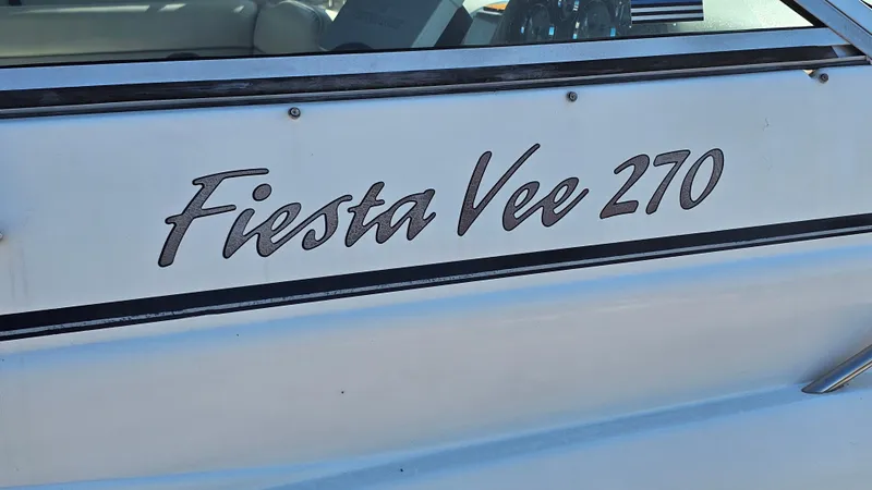 Slide: The Image of 2003 Rinker Fiesta Vee 270 boat nameplate on white hull. - 24