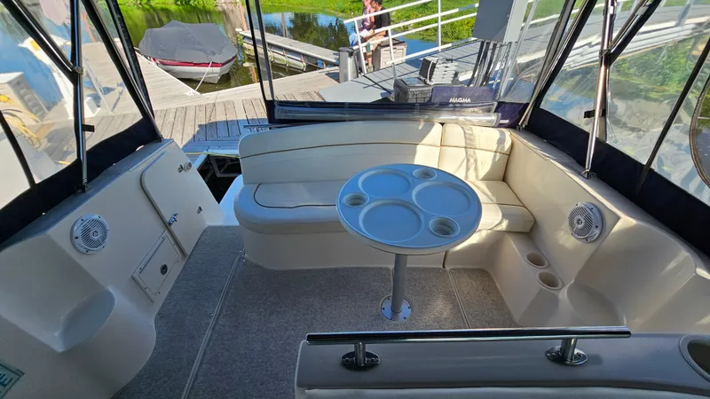 Slide: The Image of 2003 Rinker Fiesta Vee 270 boat interior with seating and table, docked at marina. - 6