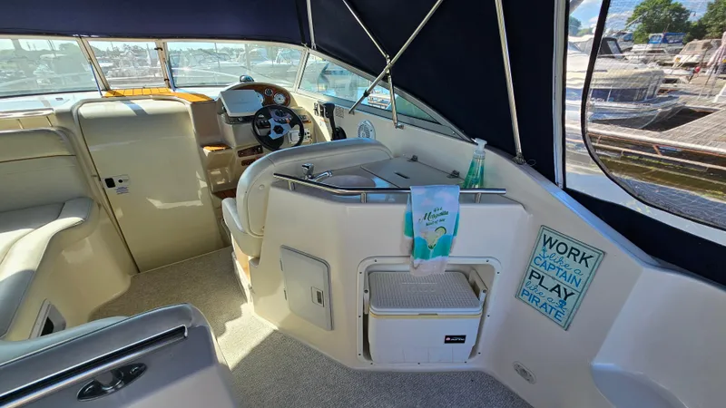 Slide: The Image of 2003 Rinker Fiesta Vee 270 boat interior with helm, seating, and nautical decor. - 7