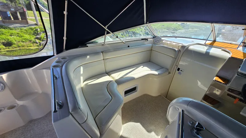 Slide: The Image of 2003 Rinker Fiesta Vee 270 boat interior with cushioned seating and canopy. - 8