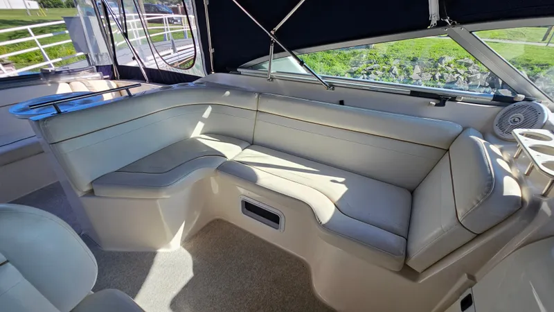 Slide: The Image of 2003 Rinker Fiesta Vee 270 boat interior with beige seating and windows. - 9