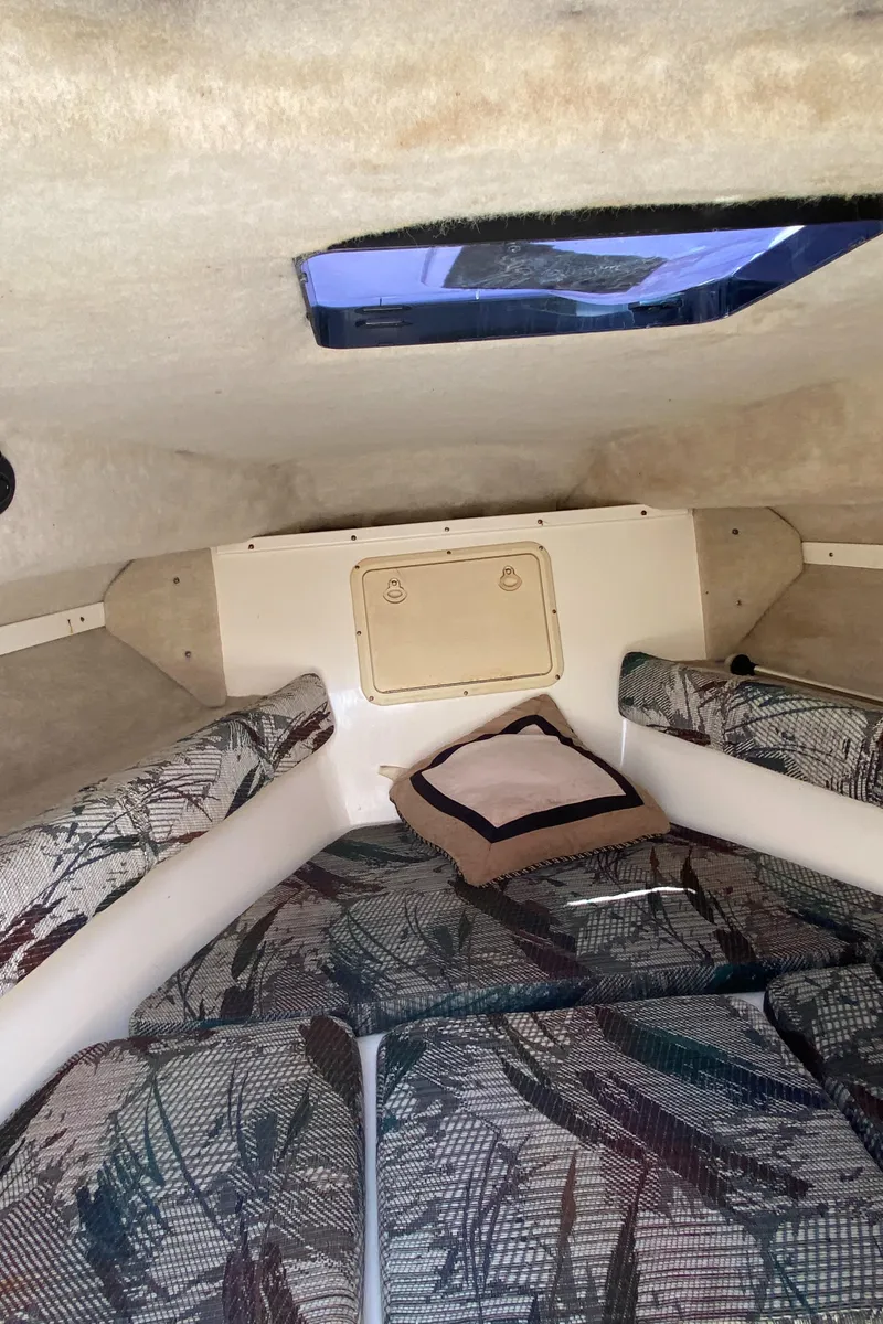 Slide: The Image of Interior cabin of 1999 Key West 2020WA Bluewater boat with patterned cushions and small window. - 12