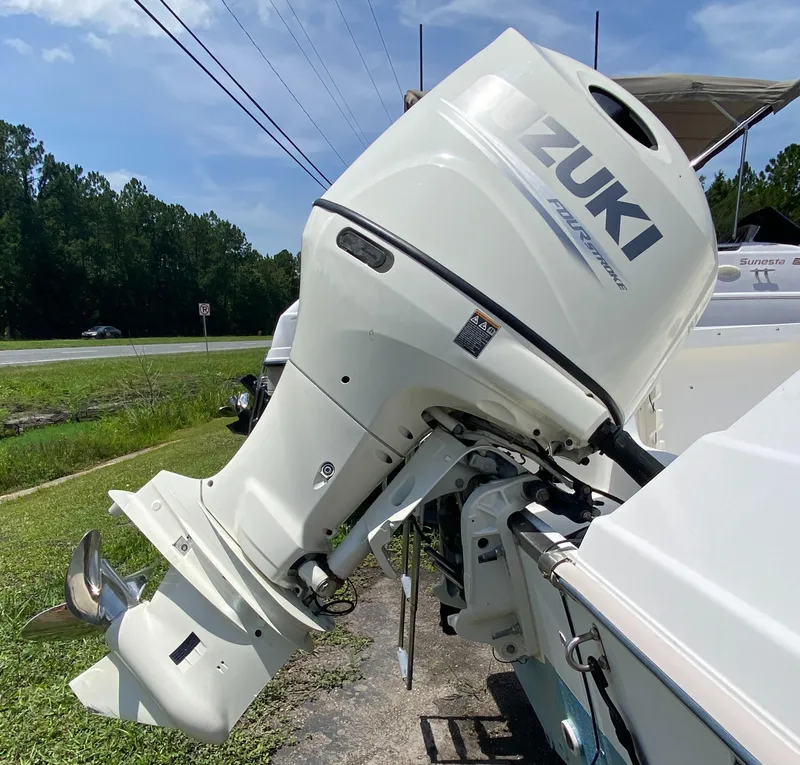 Slide: The Image of Outboard motor on a 1999 Key West 2020WA Bluewater boat, parked on grass. - 5