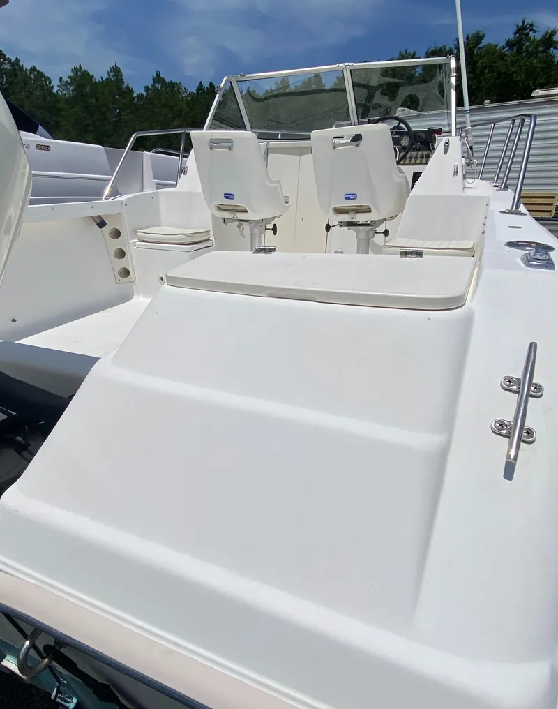 Slide: The Image of 1999 Key West 2020WA Bluewater boat interior with white seating and steering console. - 6