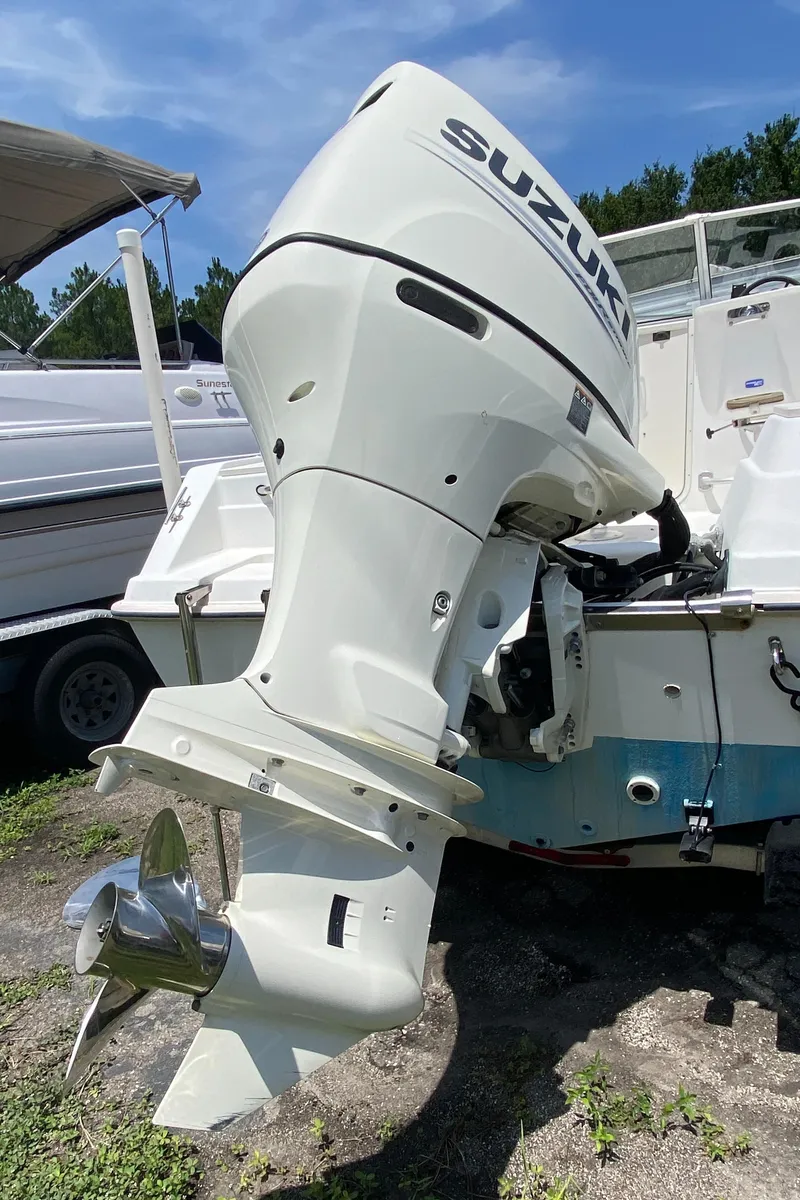 Slide: The Image of Outboard motor on a 1999 Key West 2020WA Bluewater boat, parked on grass. - 7